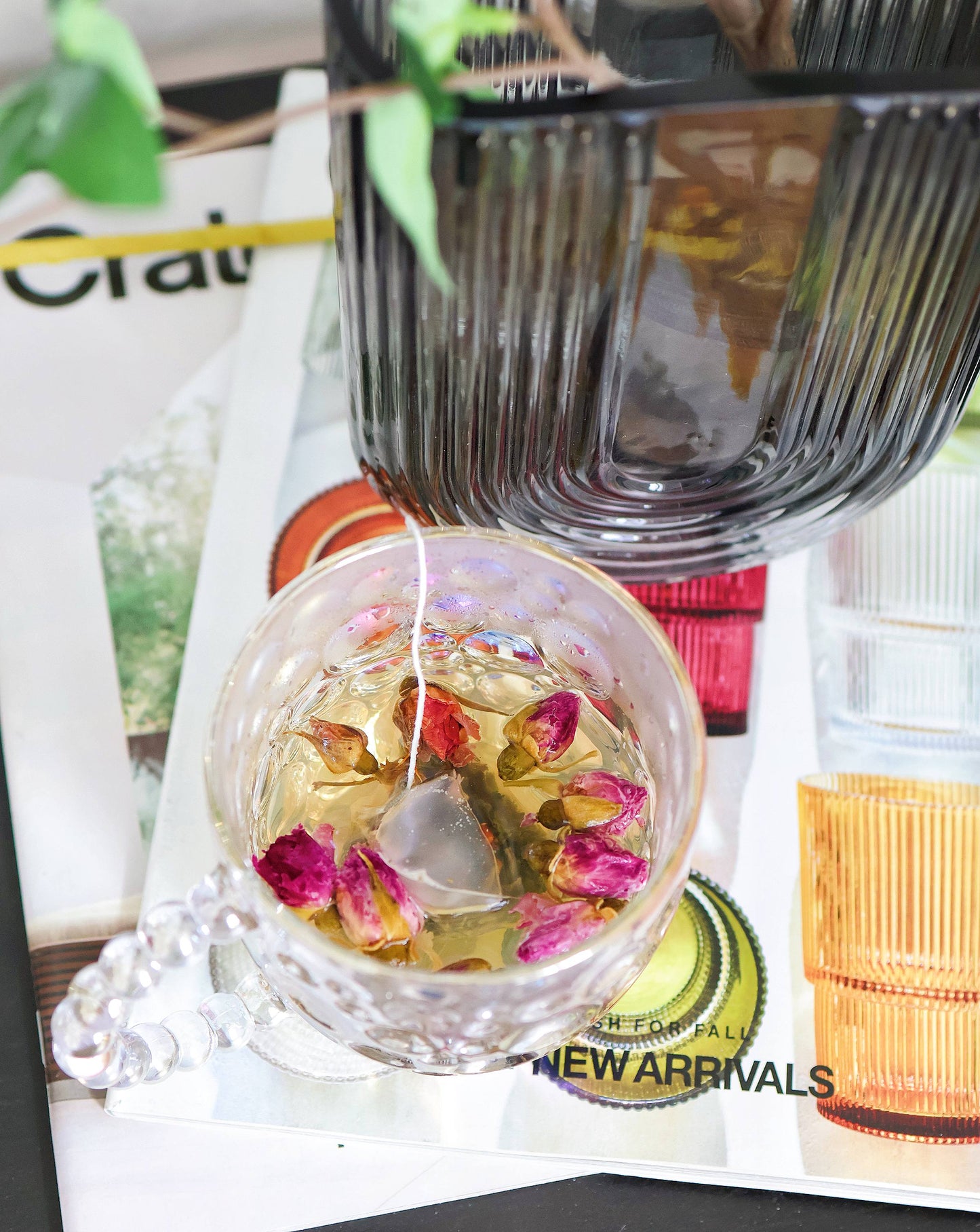 Glass mug with tea, highlighting its elegant design and pearl handle.