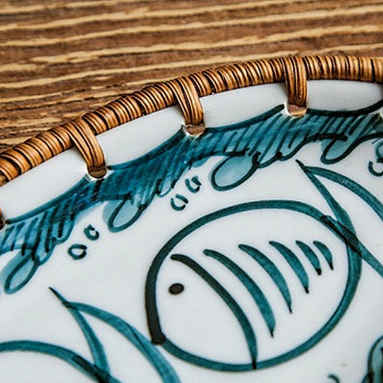 Close-up of intricate hand-painted floral and geometric patterns on a Japanese rattan snack plate, showcasing vibrant colors and artisan craftsmanship