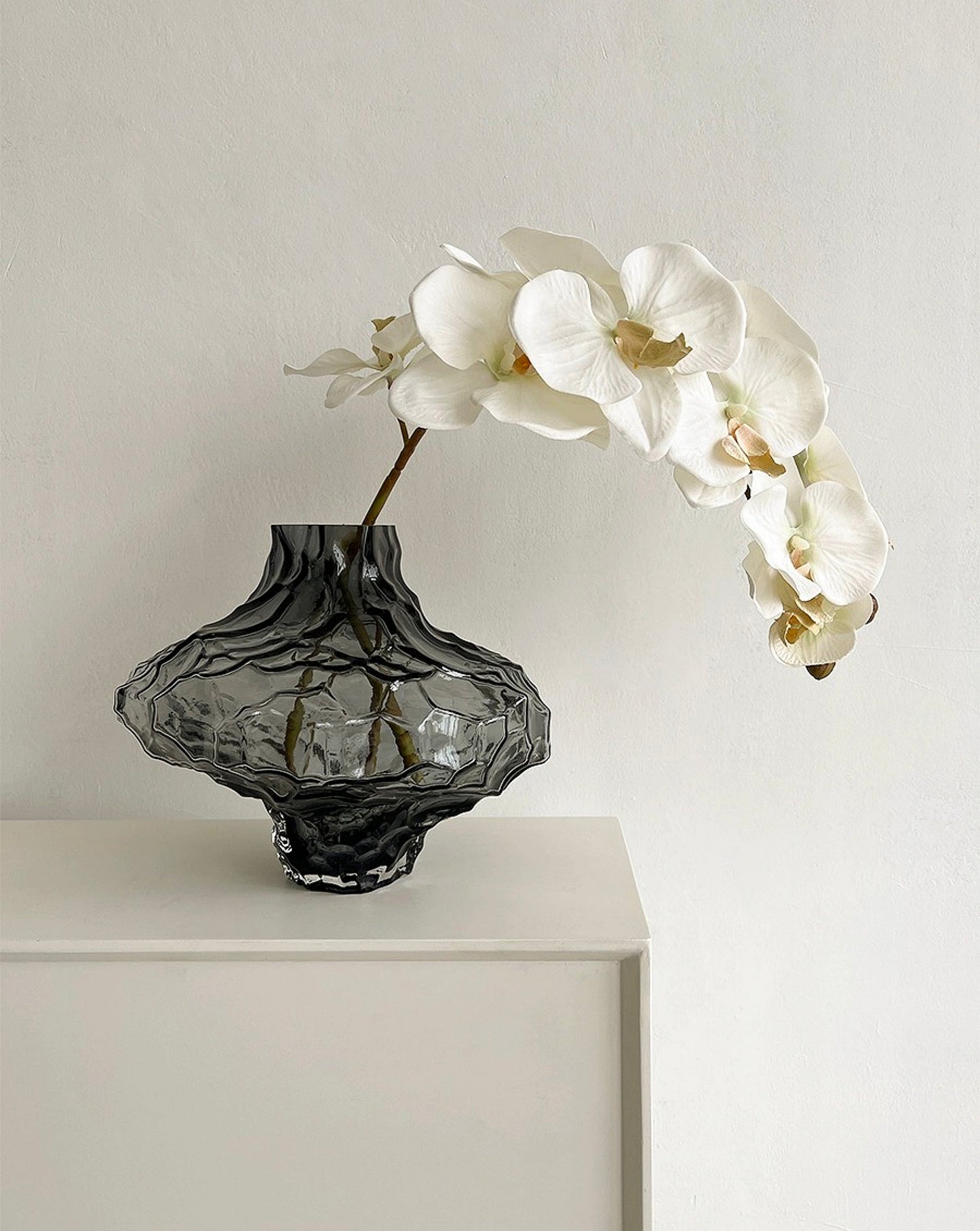 Handmade glass vase filled with flowers, adding a natural touch to any space.