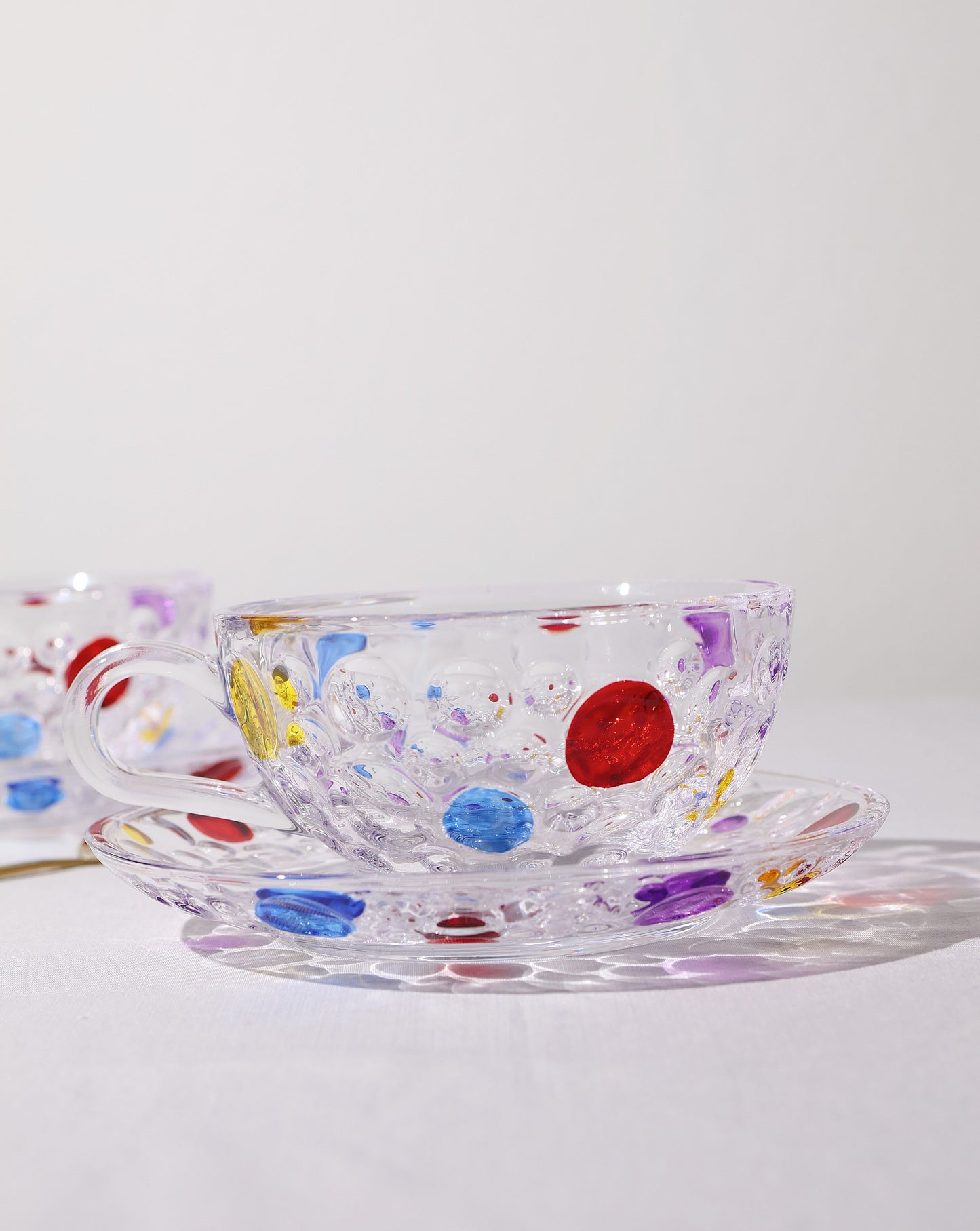 Side view of the polka dot glass cup, highlighting its textured surface and hand-painted details.