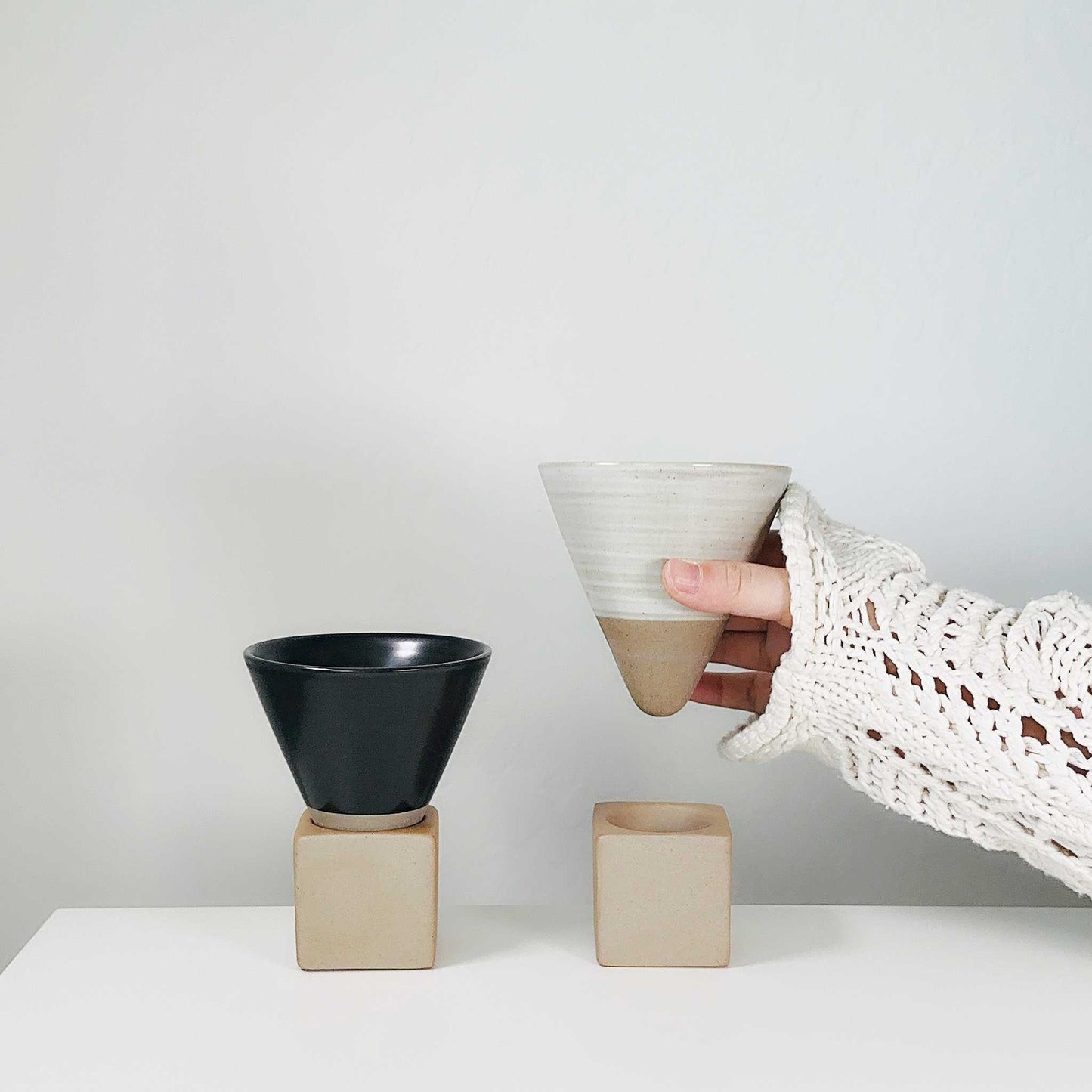 Front view of the hand-painted ceramic coffee cup, showcasing its geometric cone shape and earthy design.