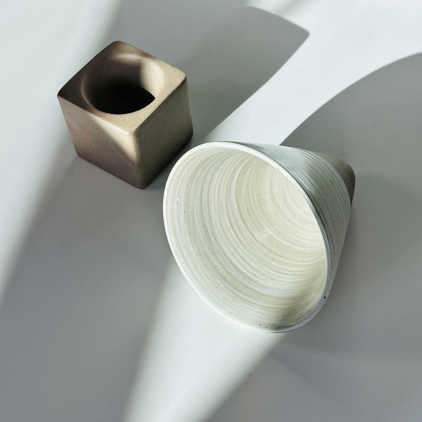 Ceramic cup in a Japanese Zen setting, embodying the wabi-sabi philosophy of imperfection.