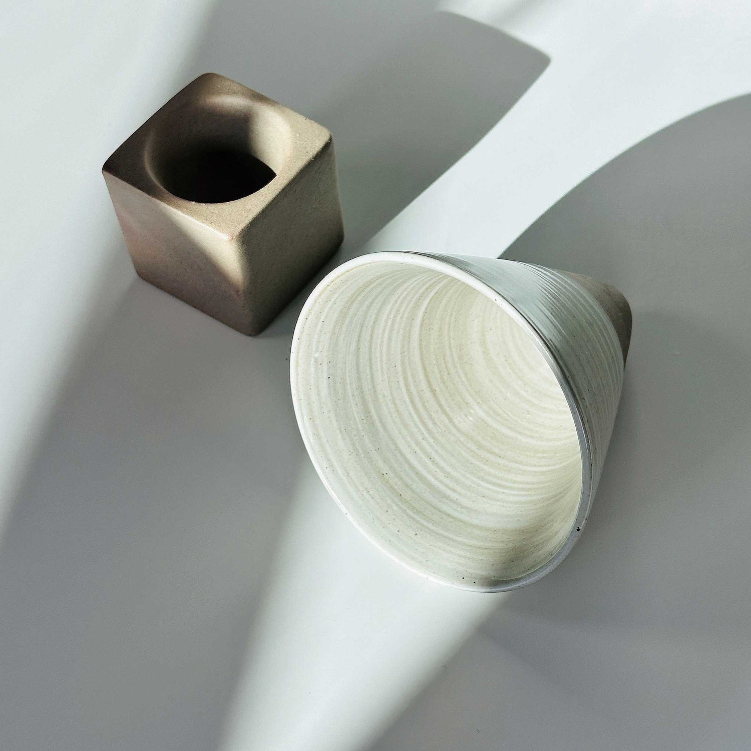 Ceramic cup in a Japanese Zen setting, embodying the wabi-sabi philosophy of imperfection.
