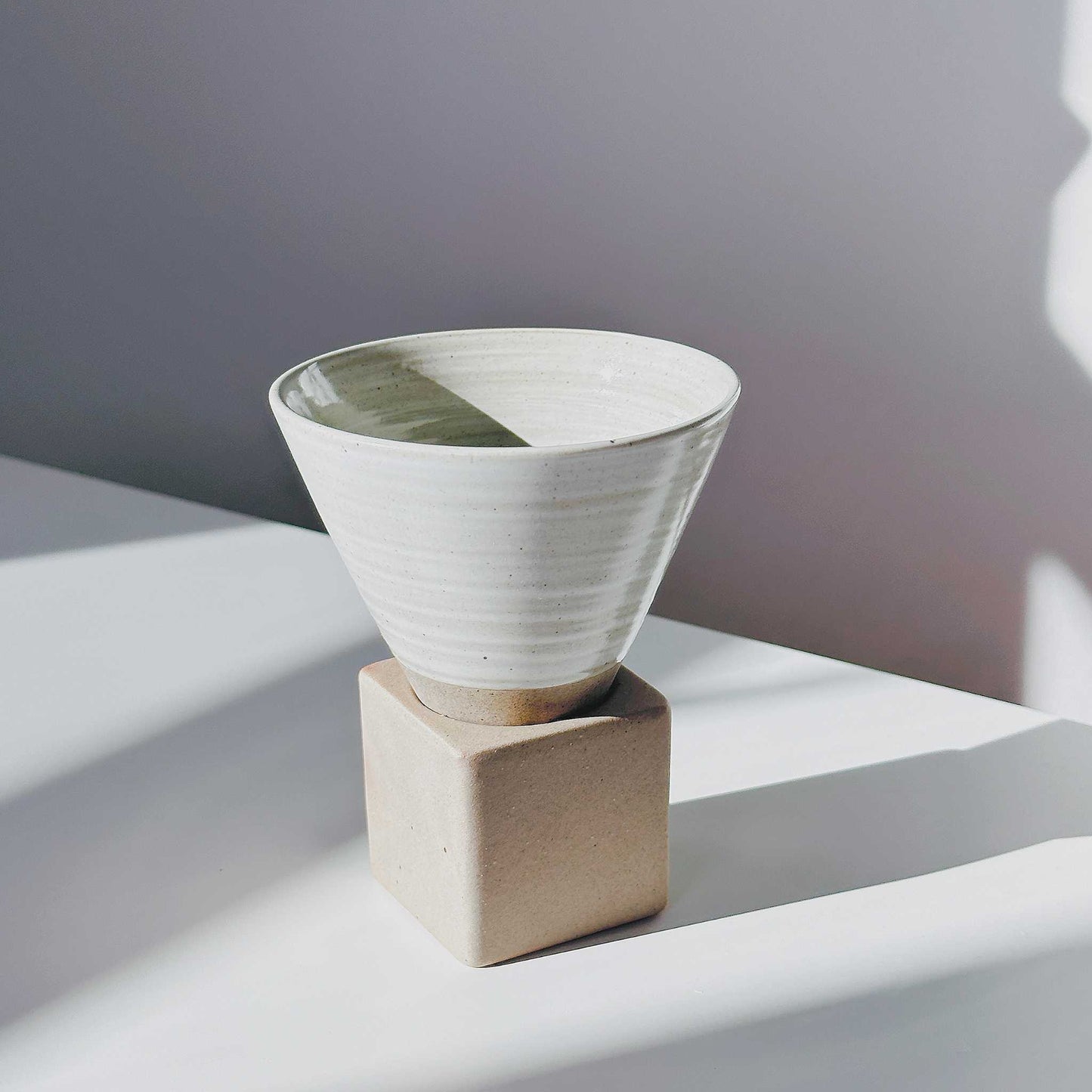 Side view of the ceramic cup, highlighting its unique hand-painted finish and natural texture.