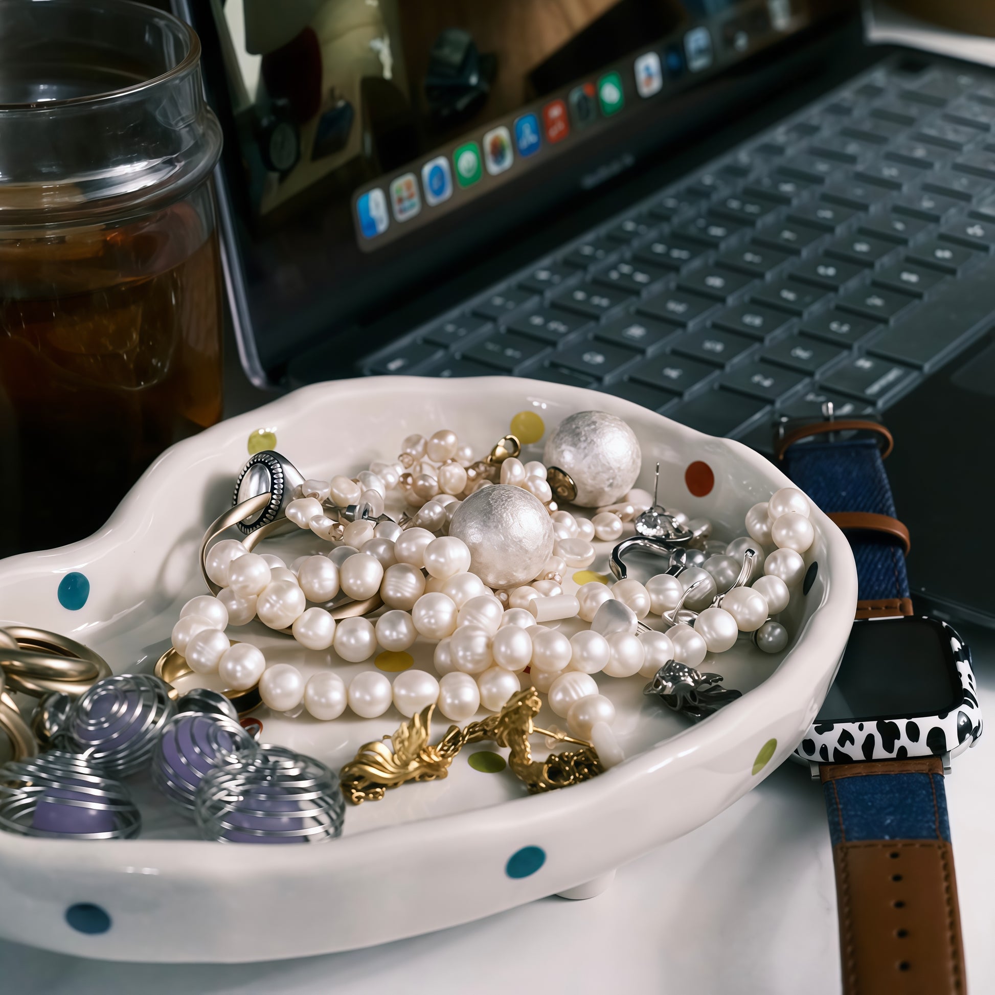 Polka dot tray organizing nightstand essentials like glasses and keys.