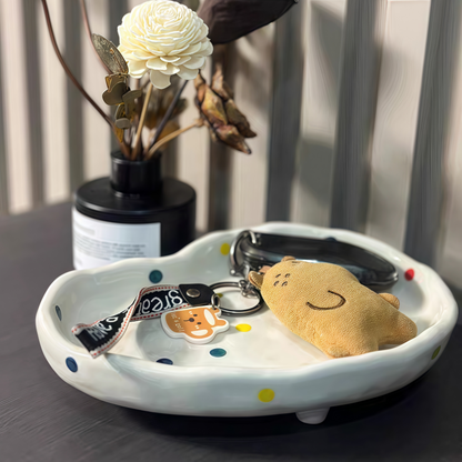 Polka dot ceramic tray with three sturdy legs, perfect for organizing jewelry and accessories.