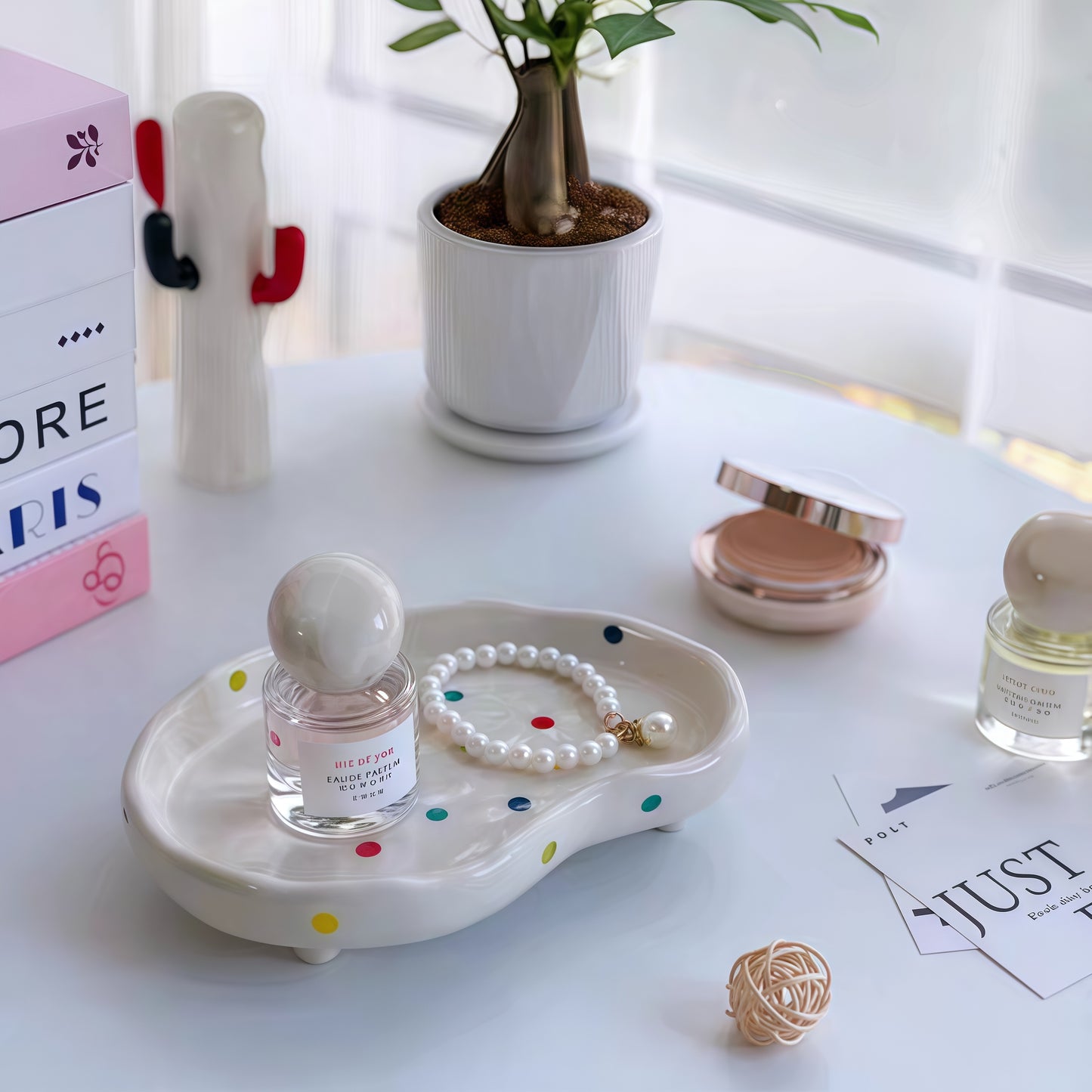 Polka dot decorative tray organizing perfumes, cosmetics, and jewelry on a vanity.