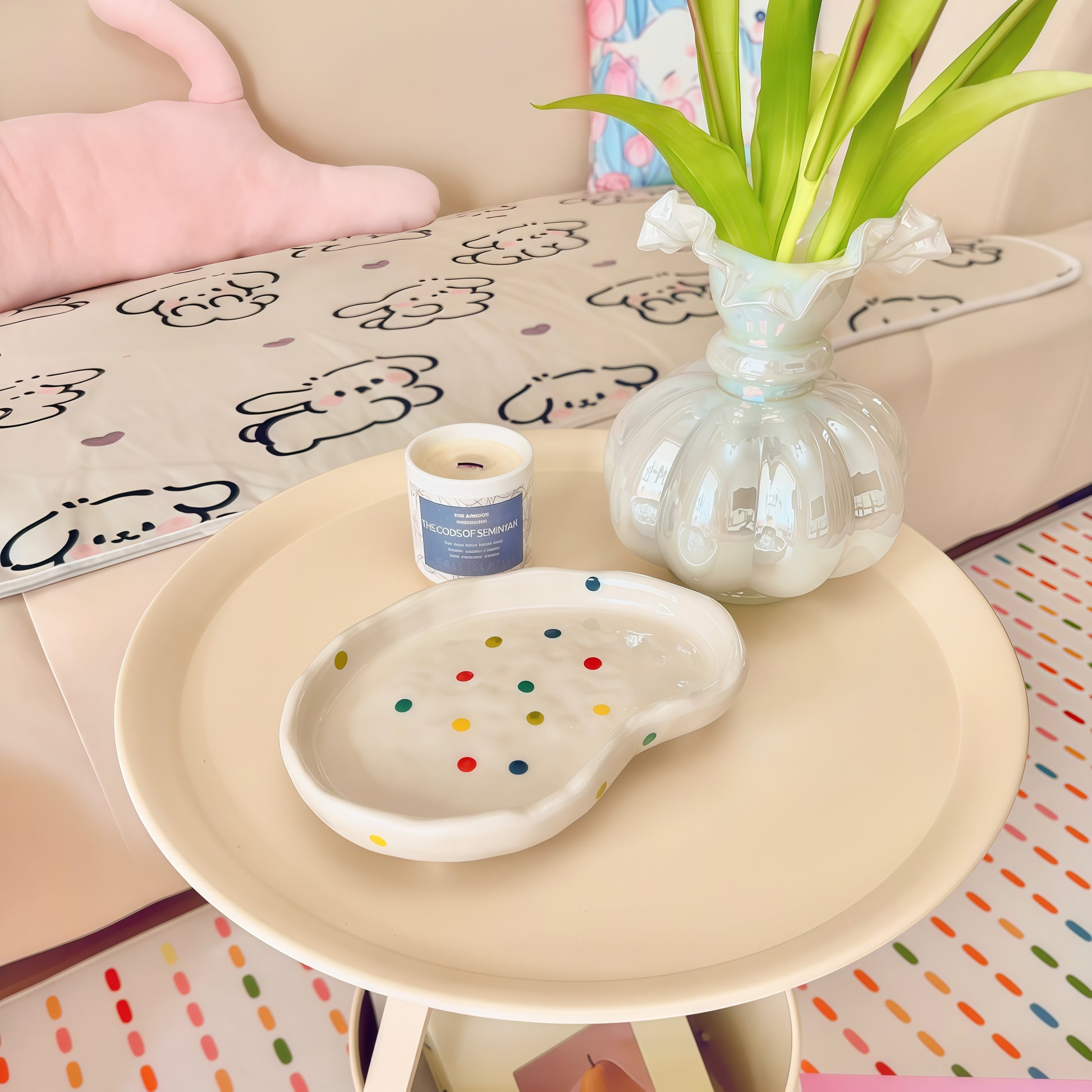 polka dot decorative tray holding candles and small accessories on a coffee table.