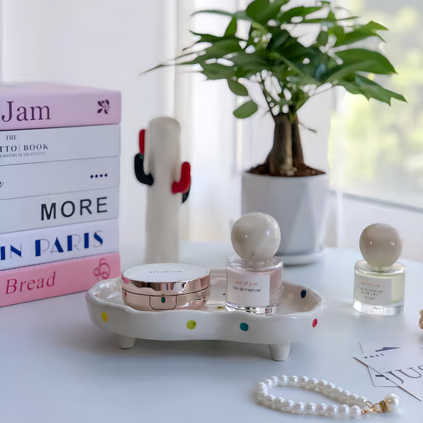 Ceramic polka dot tray displaying perfume bottles and jewelry for easy access and organization.