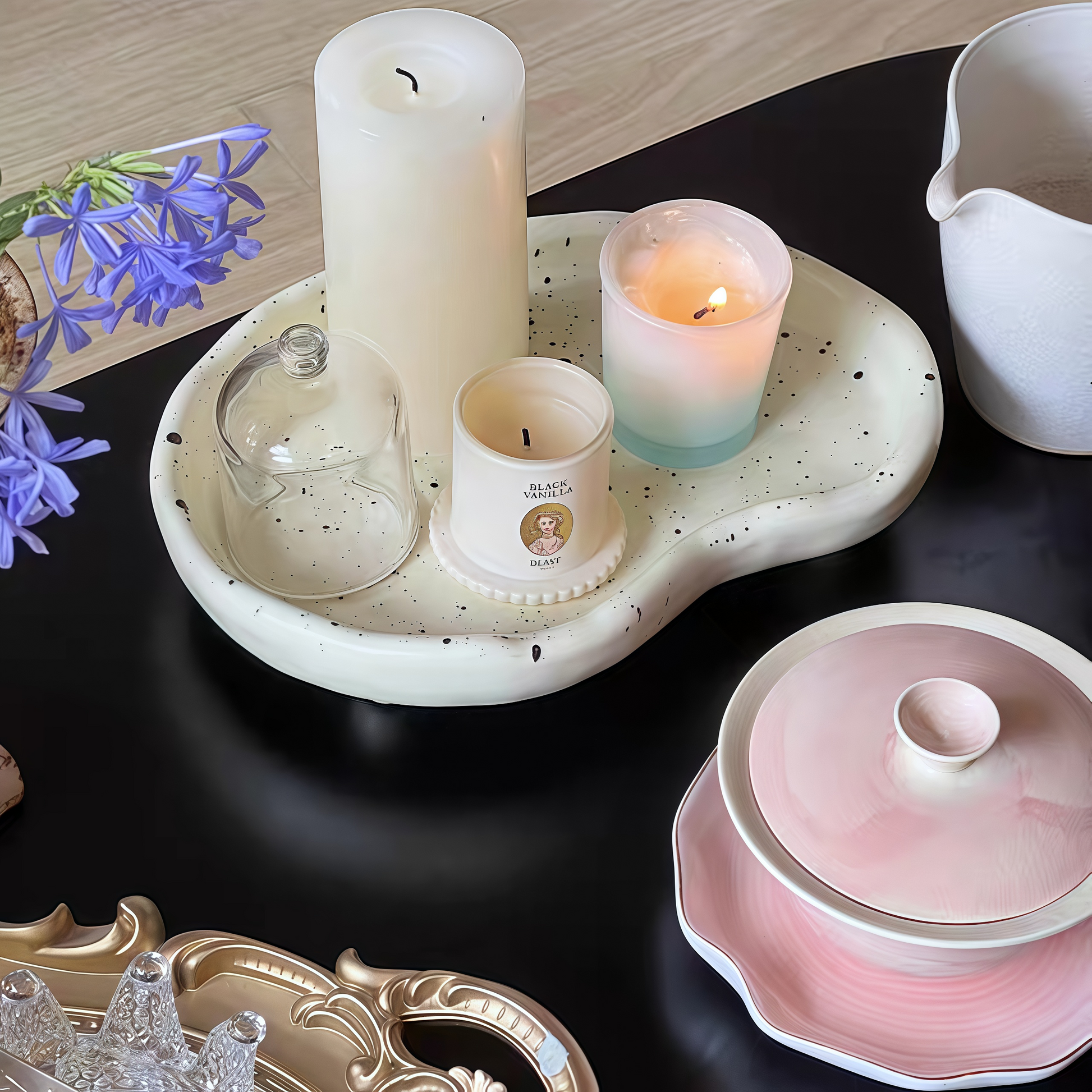 Decorative splatter tray holding candles and small accessories on a coffee table for a chic look.