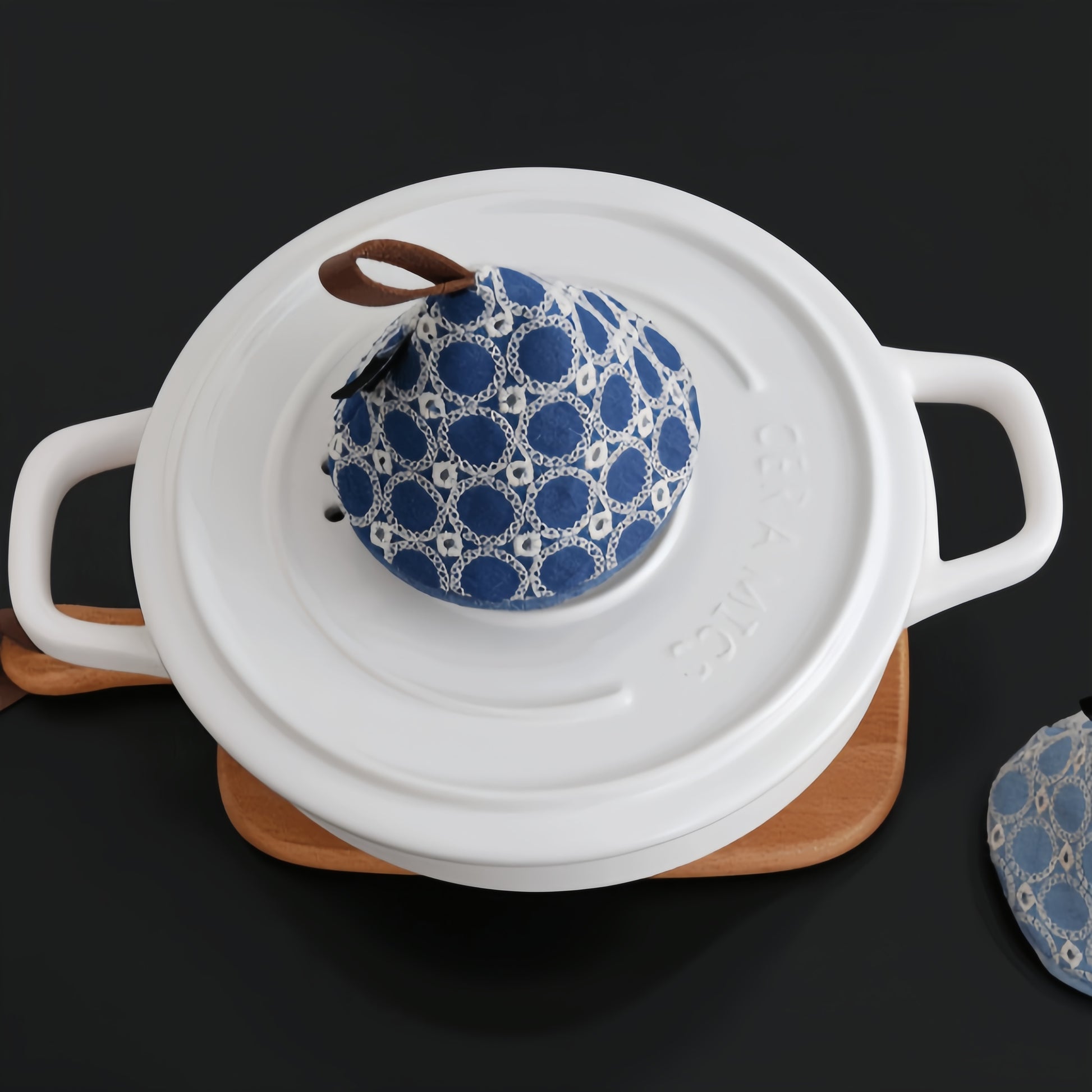 Safely lifting a hot pot lid using the textured cotton pot cap to avoid burns in the kitchen.

