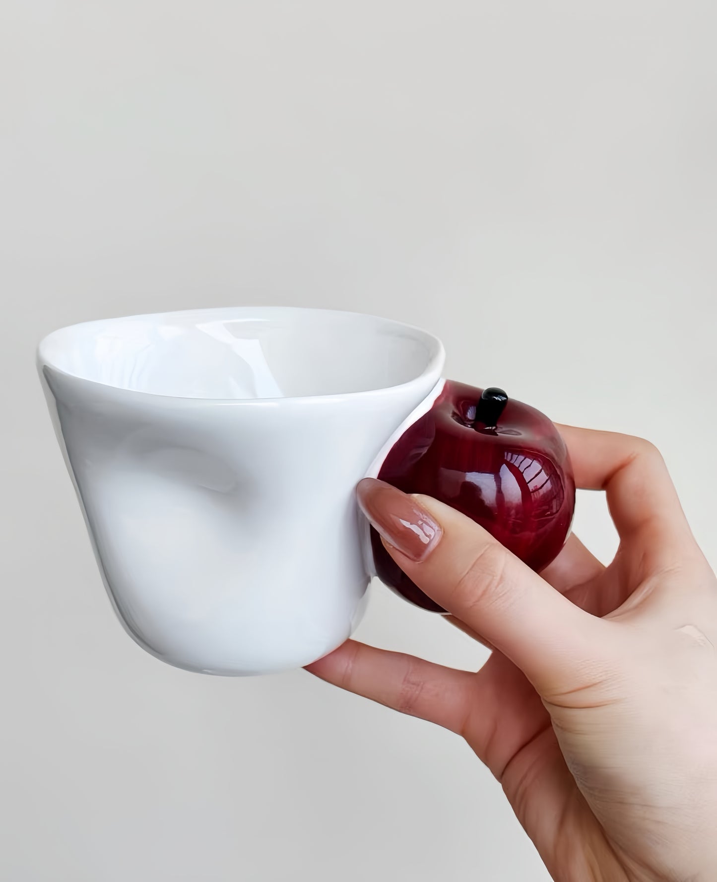 Cup paired with coffee beans and pastry in warm breakfast scene.