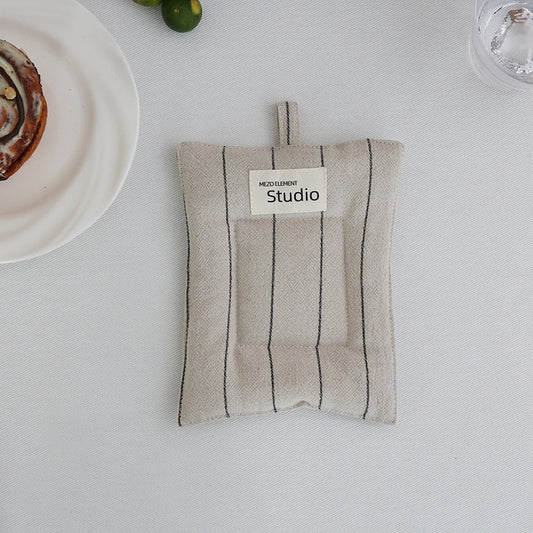 Heat-resistant cotton linen coasters under pots and pans in a kitchen.