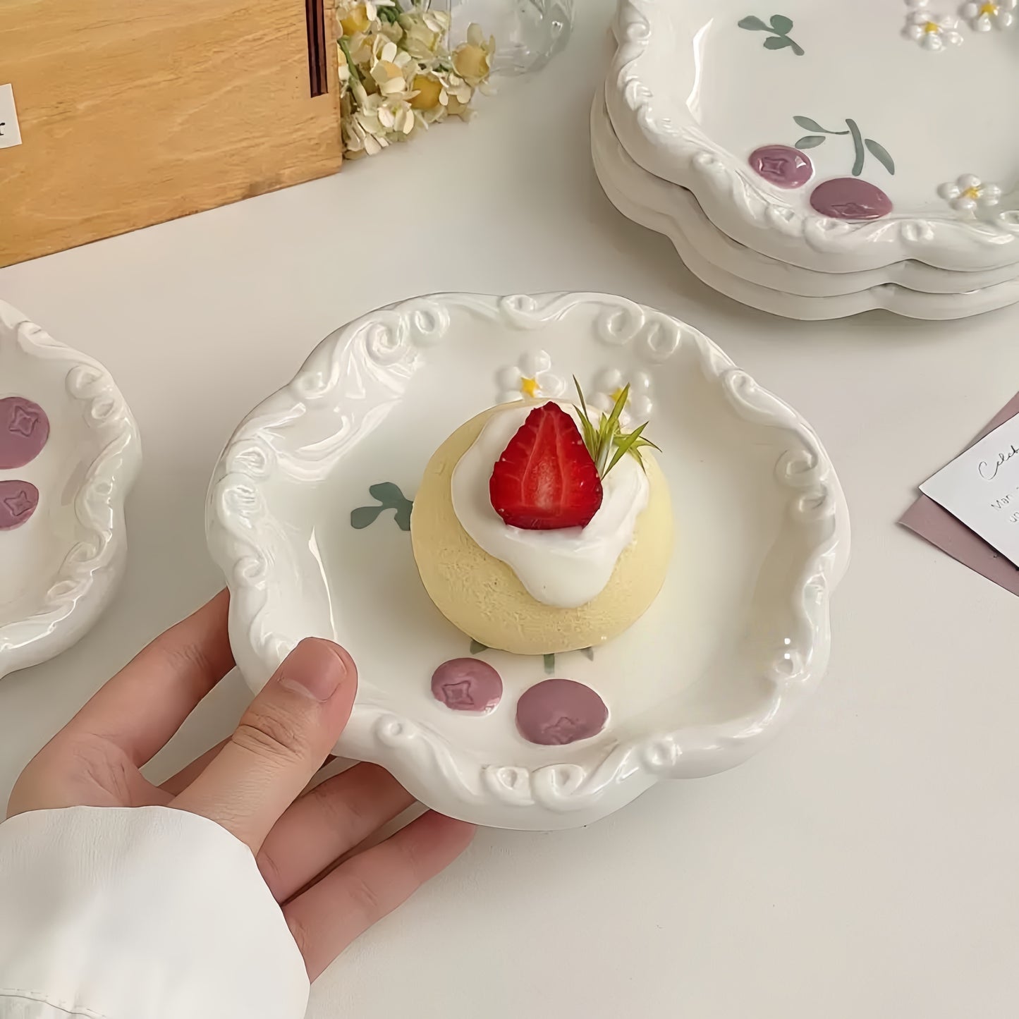 The decorative blueberry plate elegantly presenting a slice of layered artisan cake.