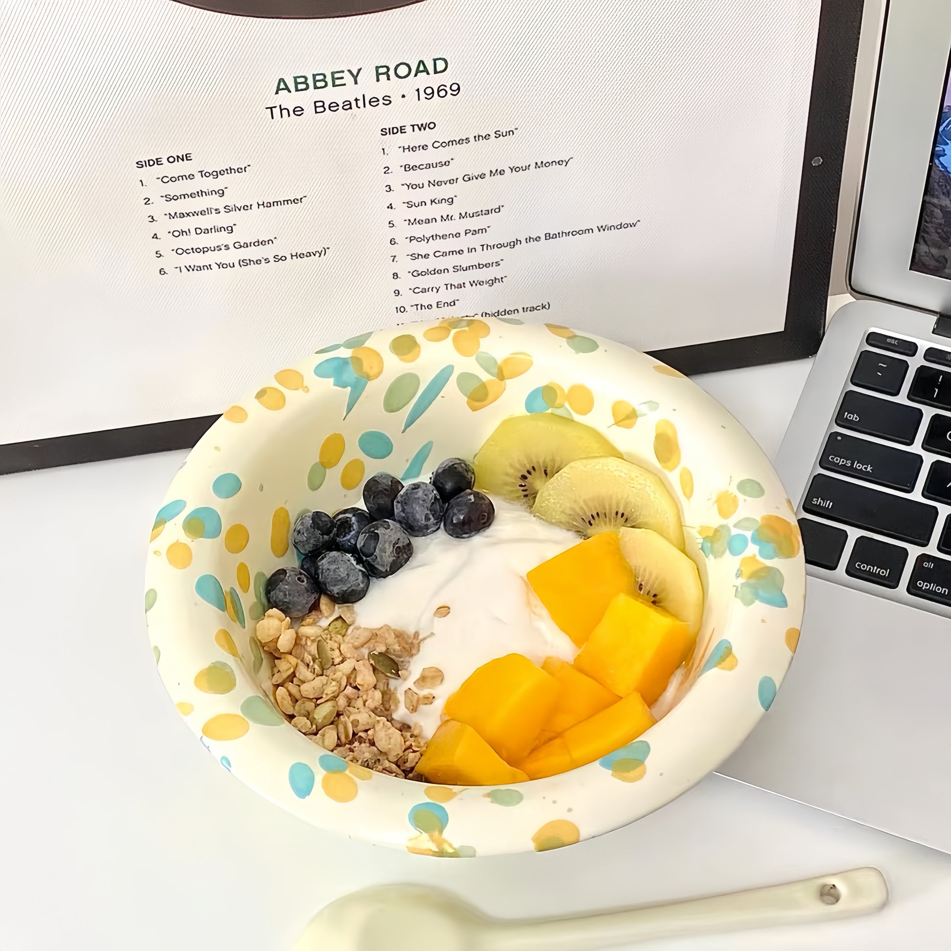 Splatter-glazed ceramic bowl filled with colorful cereal and milk on a wooden table.