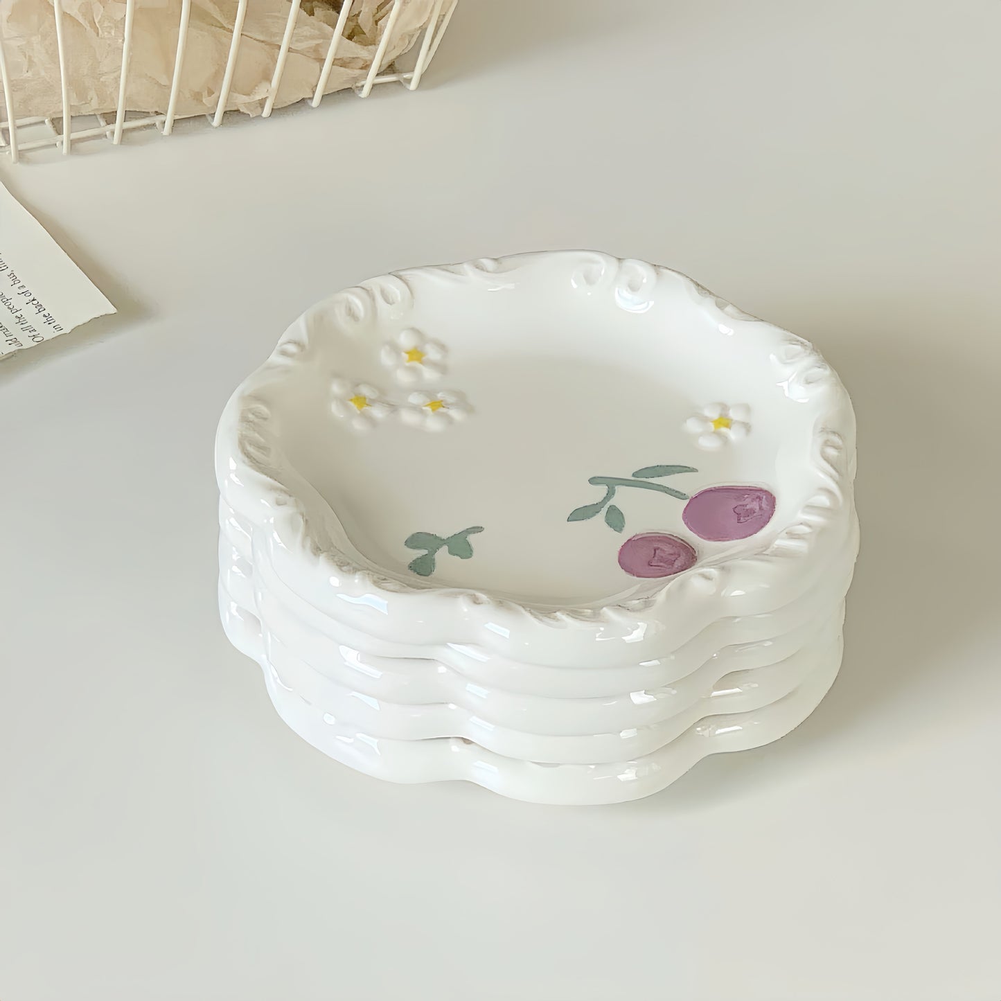 A set of four matching artisan dessert plates stacked together for a beautiful table setting.